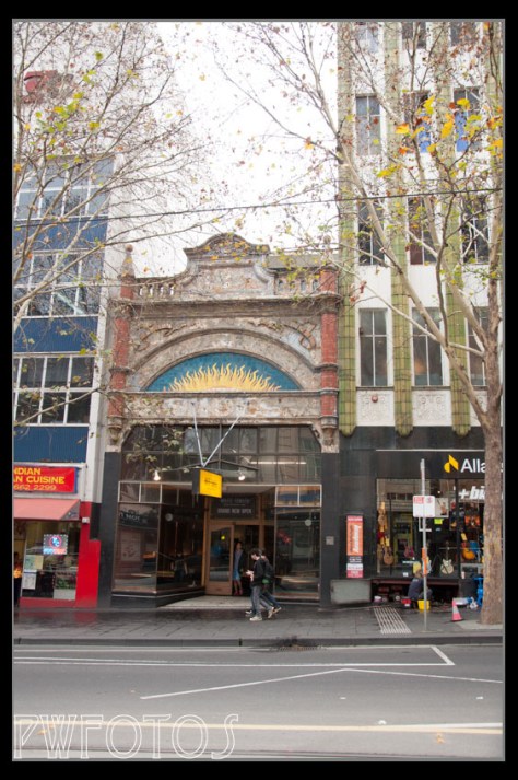 A lone single story building on Coliins Street is dwarfed by its neighbours